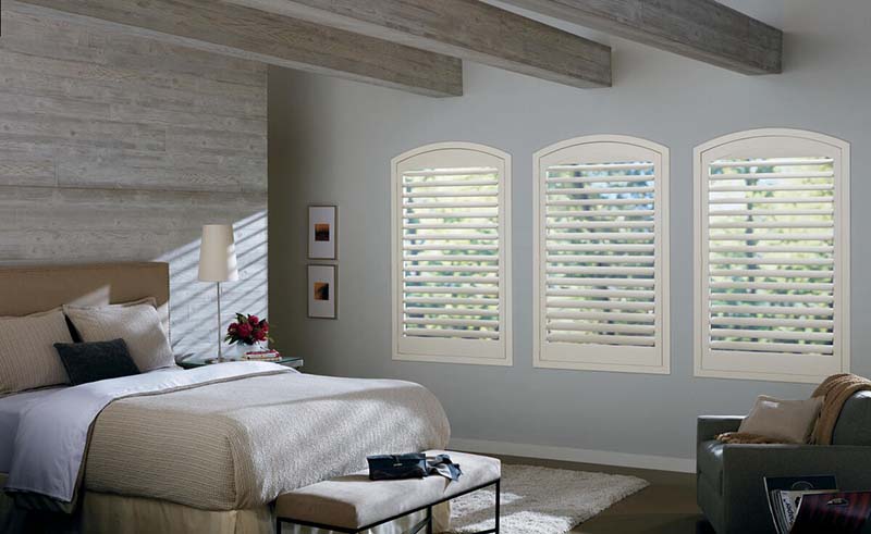White vinyl shutters in bedroom custom design from Blinds by Design
